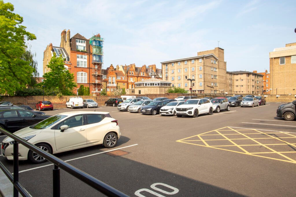 Before image: broad panorama from the Royal Hospital car park shows trees, low walls and open sky between buildings.